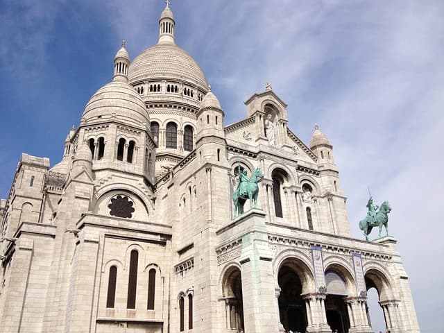 Fachada e cúpulas de pedra branca da Basílica de Sacré-Cœur, vistas de baixo