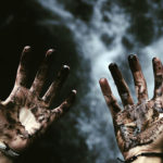 Mãos sujas e fumaça no escuro
