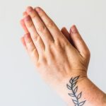 Mãos em oração iluminadas por luz natural suave, simbolizando a virtude da fé como fundamento da vida espiritual